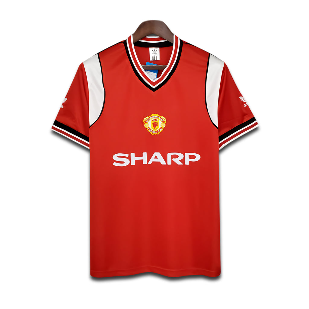 Red Manchester United jersey with 'Sharp' logo on a white background