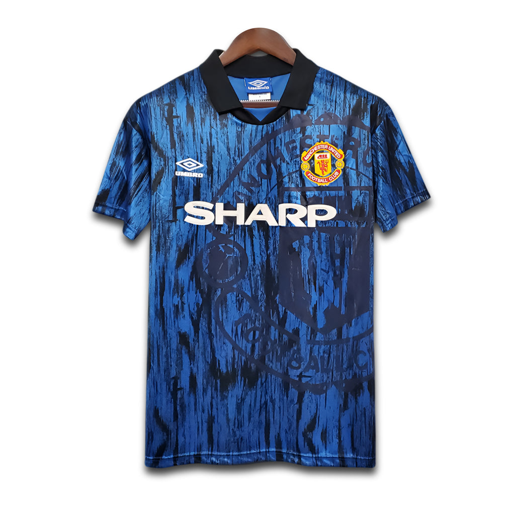 Blue Manchester United sports jersey with visible Sharp branding on a white background