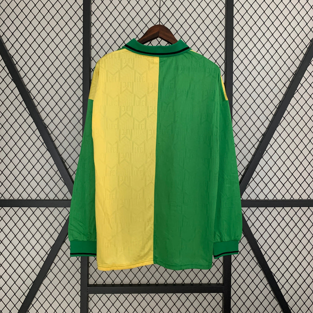 Green and yellow jersey on a hanger against a black and white geometric patterned background