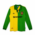 A long-sleeve soccer jersey with a split yellow and green design, featuring the Manchester United crest on the left chest, a black Umbro logo on the right chest, and 'SHARP' printed across the center. The jersey is displayed flat against a white background.