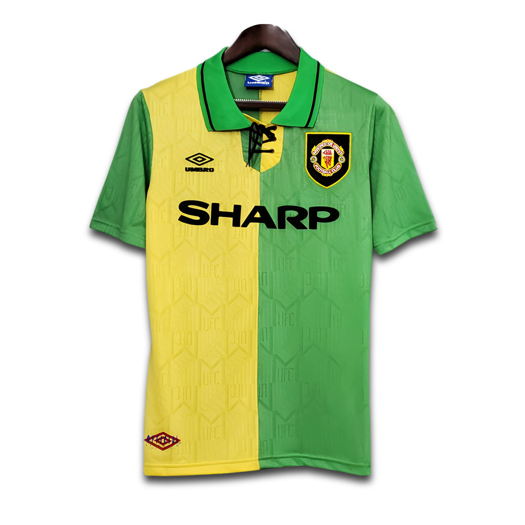 Green and yellow sports jersey with Manchester United logo and 'Sharp' branding on a white background.