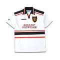 White Umbro Manchester United jersey with black and red accents, featuring a logo and text on a white background