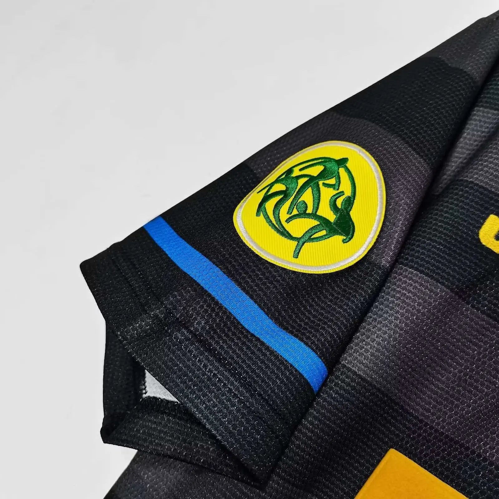 Black martial arts gi with a logo and brand name on a light gray background