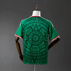 Green sports jersey with intricate patterns on a mannequin against a gray background