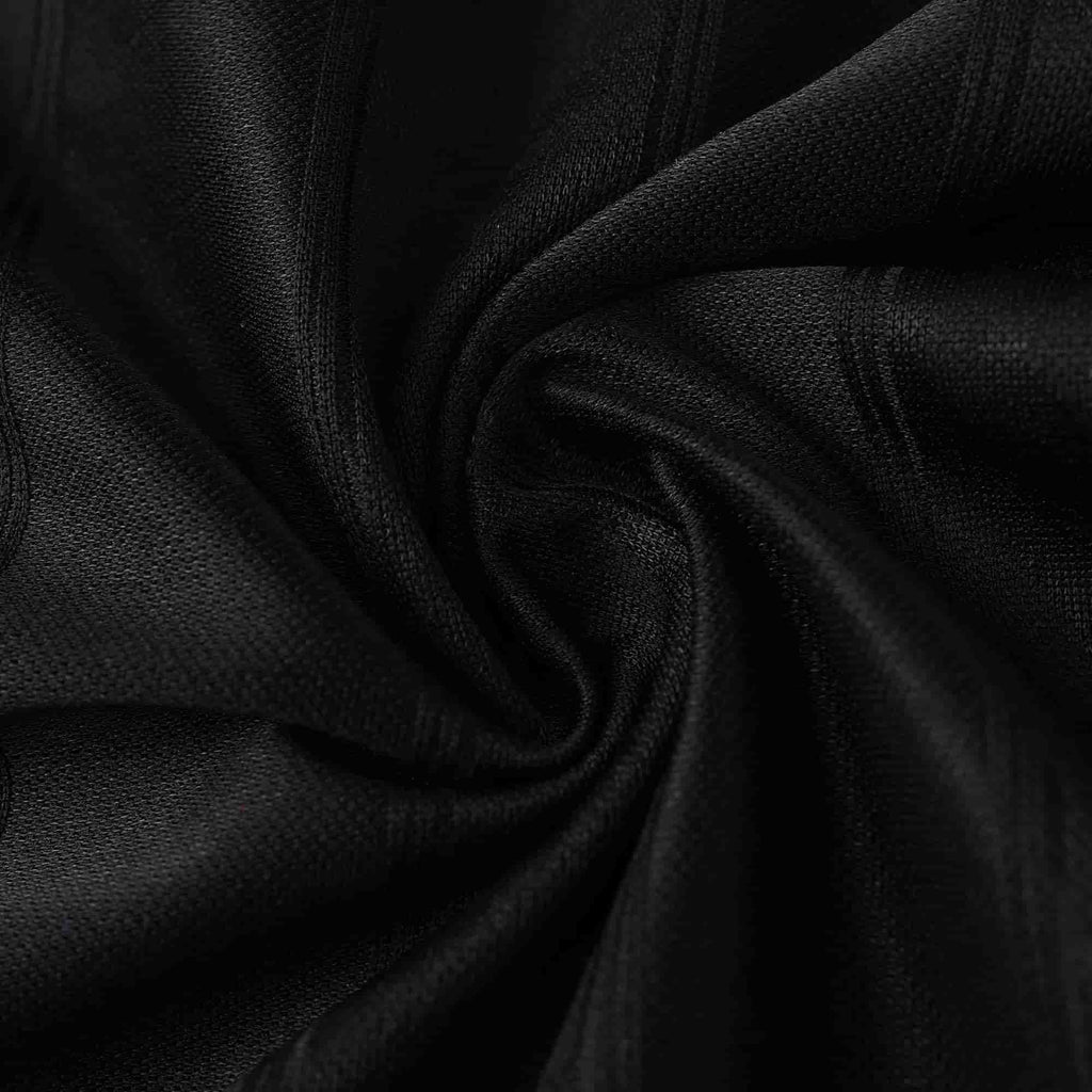 A close-up of black textured fabric arranged in a spiral drape, showing the material's fine woven texture and subtle sheen.