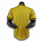 Yellow sports jersey with black and red accents on a mannequin against a white background