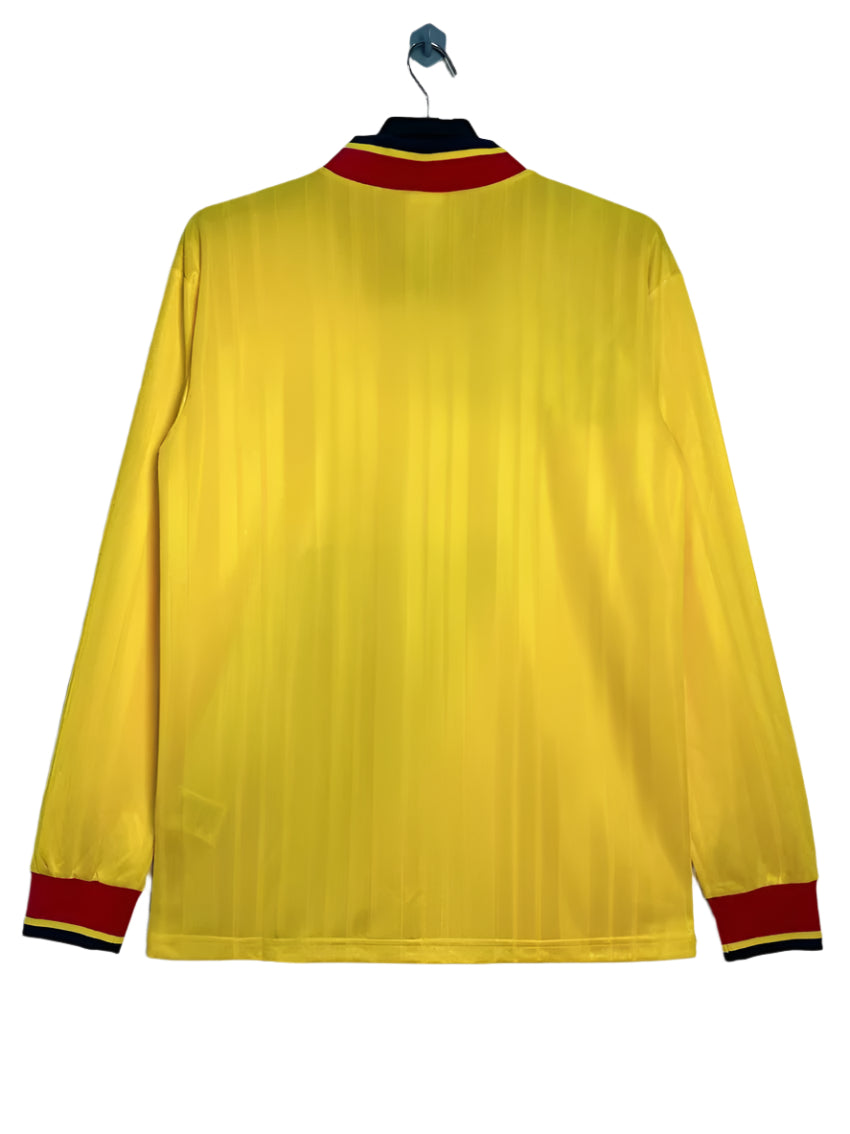 Yellow long-sleeve shirt with red and black trim on a white background