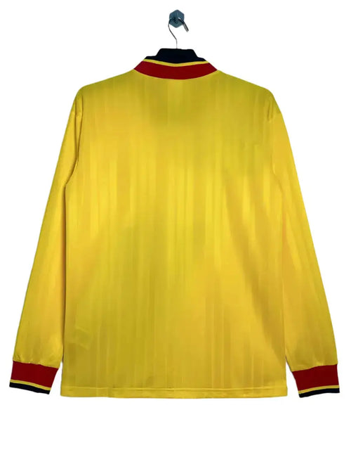 Yellow long-sleeve shirt with red and black trim on a white background