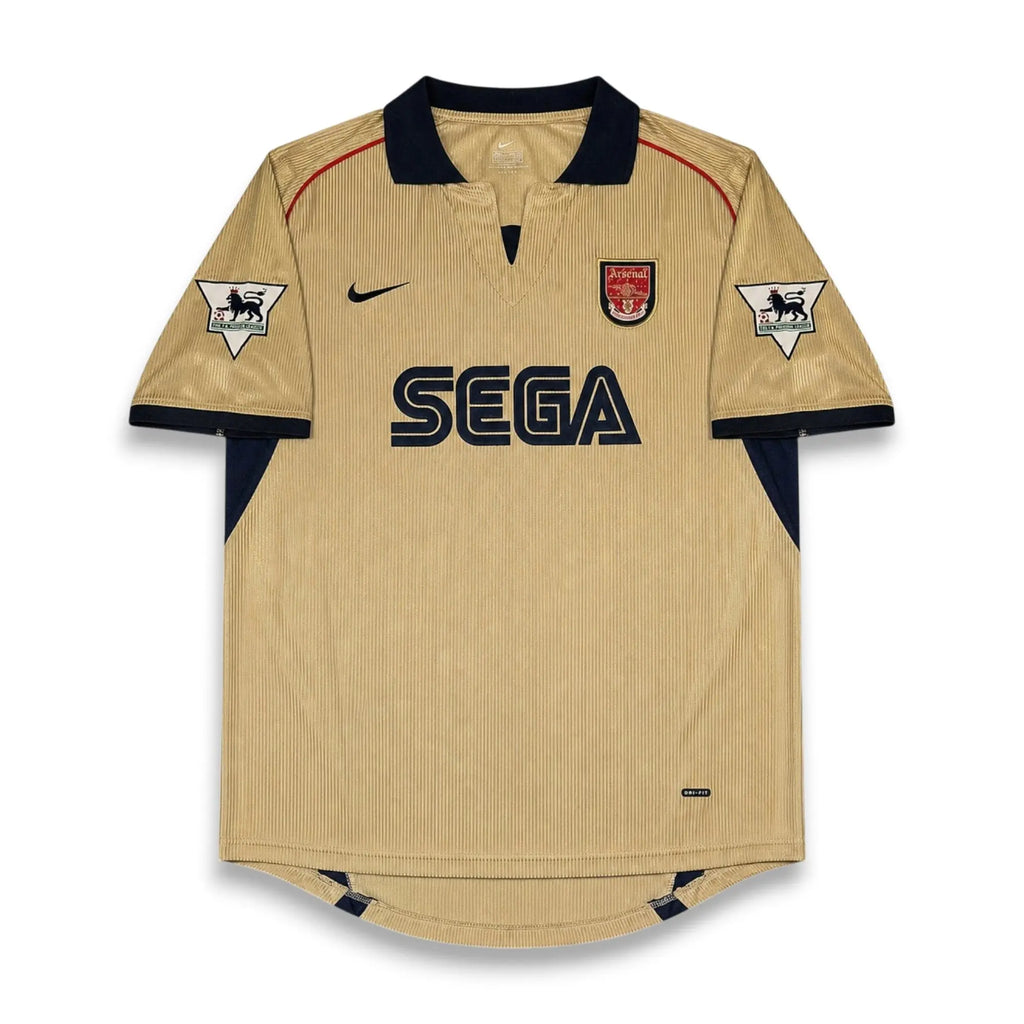 A vintage Arsenal home soccer jersey in beige with navy blue accents, featuring the SEGA sponsor logo on the chest, a Nike swoosh, and the Arsenal club crest.