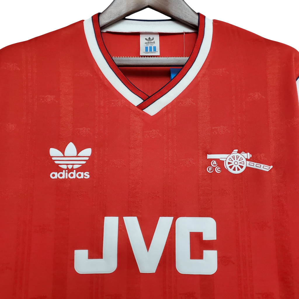 Red Arsenal jersey with Adidas logo and JVC branding on a hanger