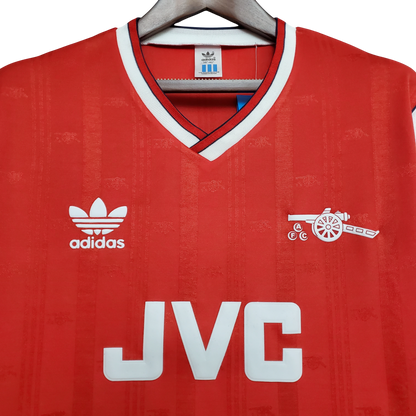 Red Arsenal jersey with Adidas logo and JVC branding on a hanger