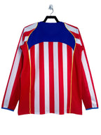 Long-sleeve shirt with red, white, and blue stripes on a hanger against a white background