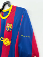 Red and blue sports jersey with FC Barcelona logo on a hanger against a white background