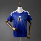 Blue sports jersey with a logo on a mannequin against a gray background