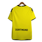 Yellow sports jersey with 'Dortmund' text on a hanger against a white background