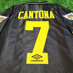 Cantona 7 on the back of a black Manchester United shirt.