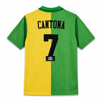 Back view of a green and yellow short-sleeve soccer jersey with 'CANTONA' and the number '7' printed in black, featuring an Umbro logo patch.