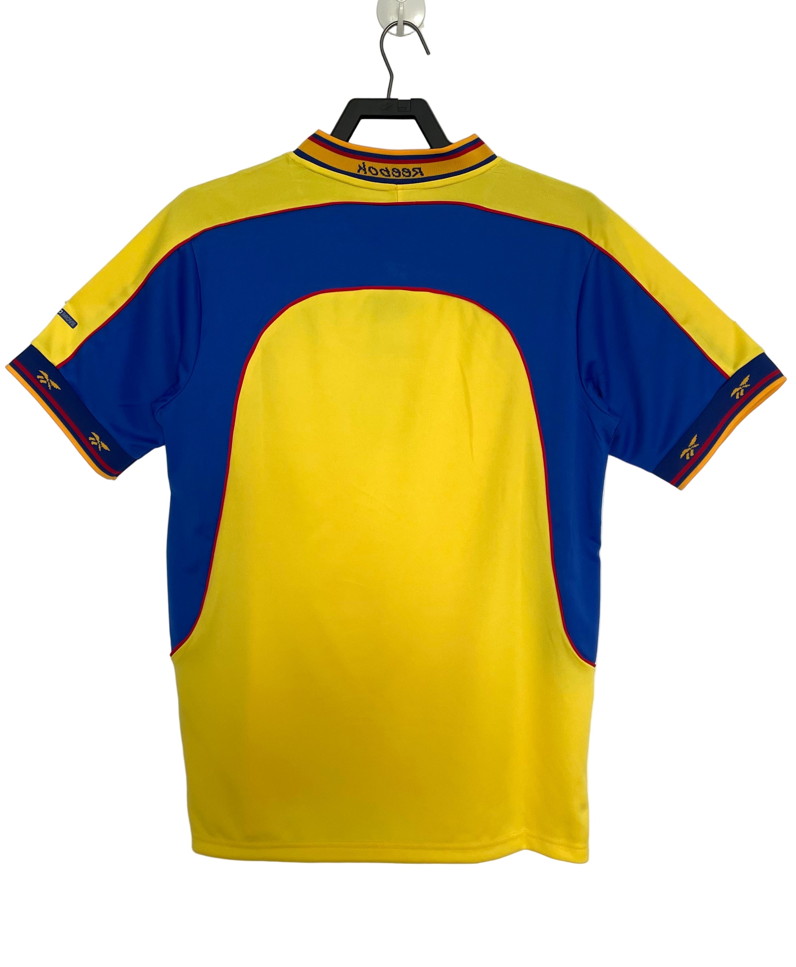 Yellow and blue Colombia soccer jersey on a hanger against a white background
