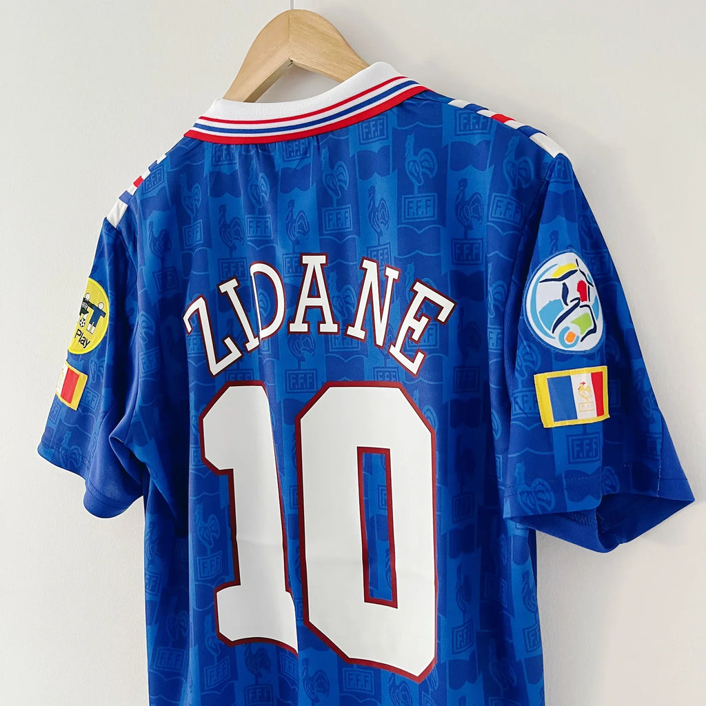 Blue soccer jersey with 'Zidane' and number '10' on a hanger against a white background