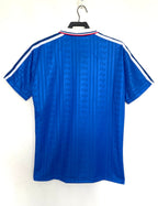 Blue sports jersey with white stripes on a hanger against a white background