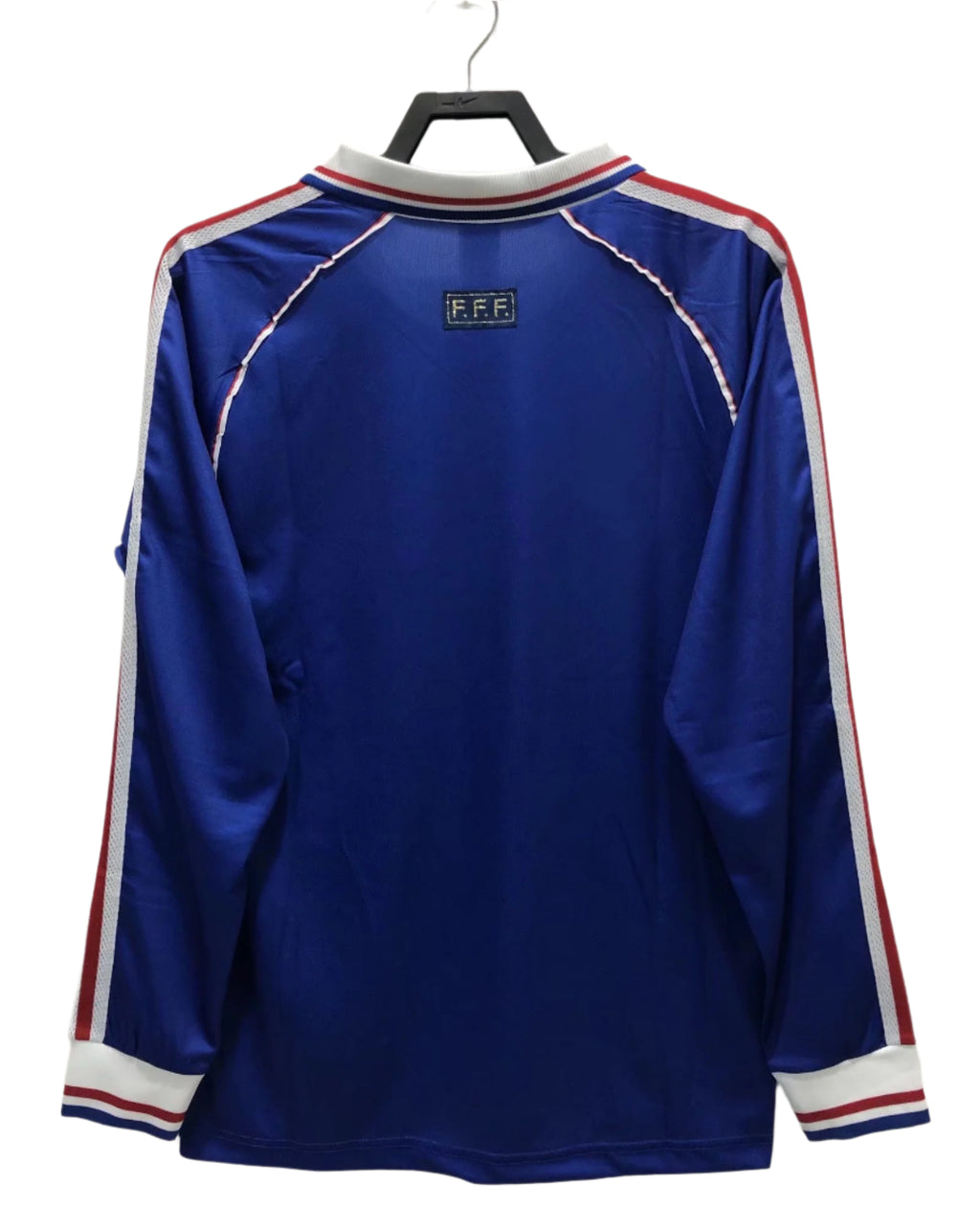 Blue sports jersey with red and white stripes on a hanger against a white background