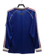 Blue sports jersey with red and white stripes on a hanger against a white background
