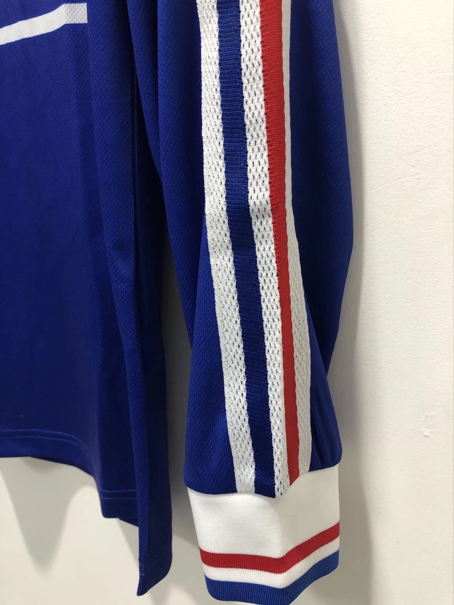 Blue sports jersey with white and red stripes on a white background