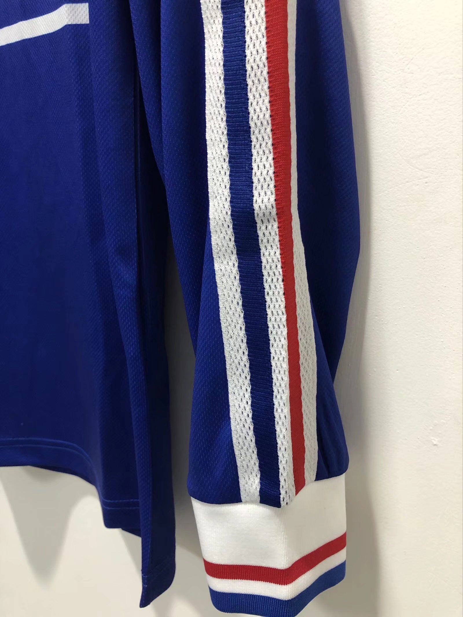 Blue sports jersey with white and red stripes on a white background