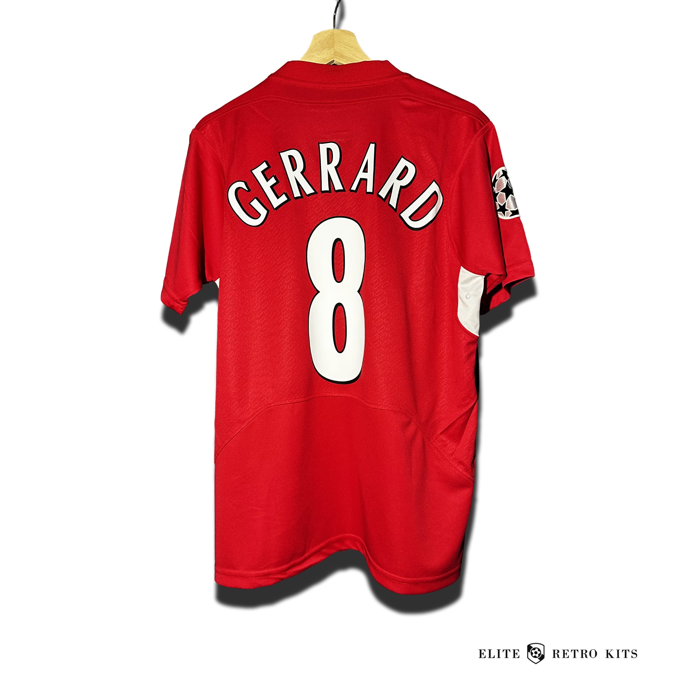 A red soccer jersey with the name 'Gerrard' and the number '8' on the back, displayed on a wooden hanger.
