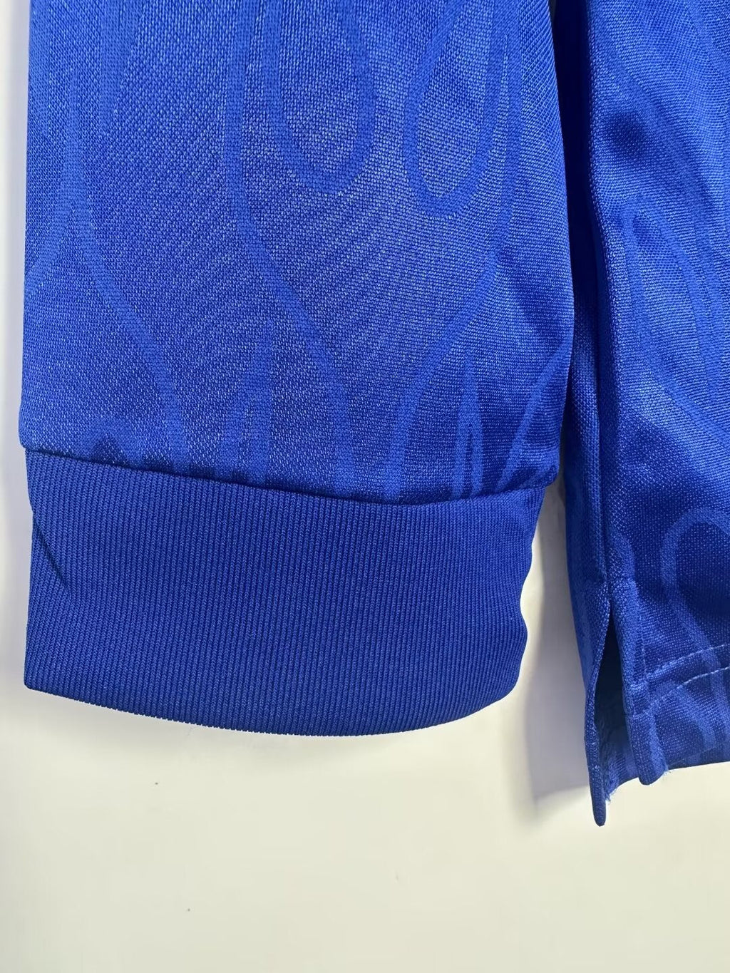 Close-up of a blue fabric with a subtle pattern on a light beige background