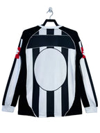 Black and white striped shirt with red accents on a hanger against a white background