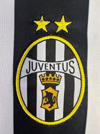 Juventus logo on a sports jersey with black and white stripes.