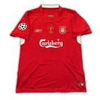 A red Liverpool FC soccer jersey from the 2004-2005 season with the UEFA Champions League final emblem and Carlsberg sponsorship logo.