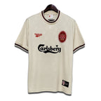 A classic Liverpool FC away jersey from the 1996/1997 season, in ecru color with green and black trim, featuring the Carlsberg sponsor and Adidas detailing.