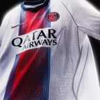 A close-up of a Paris Saint-Germain soccer jersey with a white textured body, a vertical red and navy blue stripe down the center, the PSG crest on the chest, a Nike swoosh, and the Qatar Airways sponsor logo.