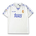 A white Real Madrid soccer jersey by Kelme, featuring blue paw print patterns on the shoulders and sleeves, the blue Teka sponsor logo on the chest, and the club's crest on the left side.