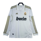 White soccer jersey with gold stripes, Adidas logo, Real Madrid emblem, and bwin sponsorship on a white background.