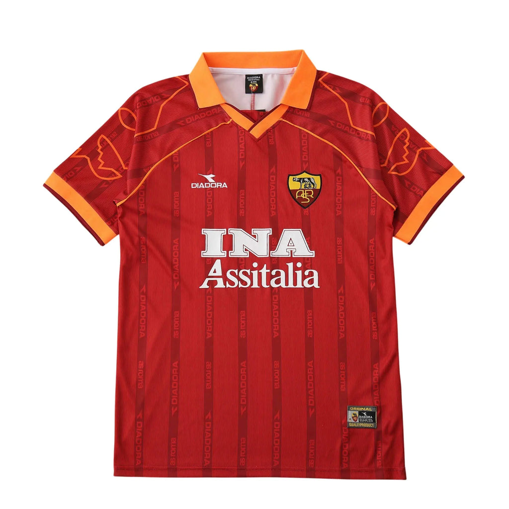 A red AS Roma soccer jersey by Diadora, featuring the white 'INA Assitalia' sponsor logo on the chest, the club crest, and orange accents on the collar and sleeve cuffs, displayed against a solid white background.