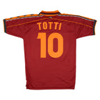 A red AS Roma soccer jersey shown from the back, featuring the player name 'TOTTI' and number '10' in orange. The jersey has orange and black striped shoulder details.