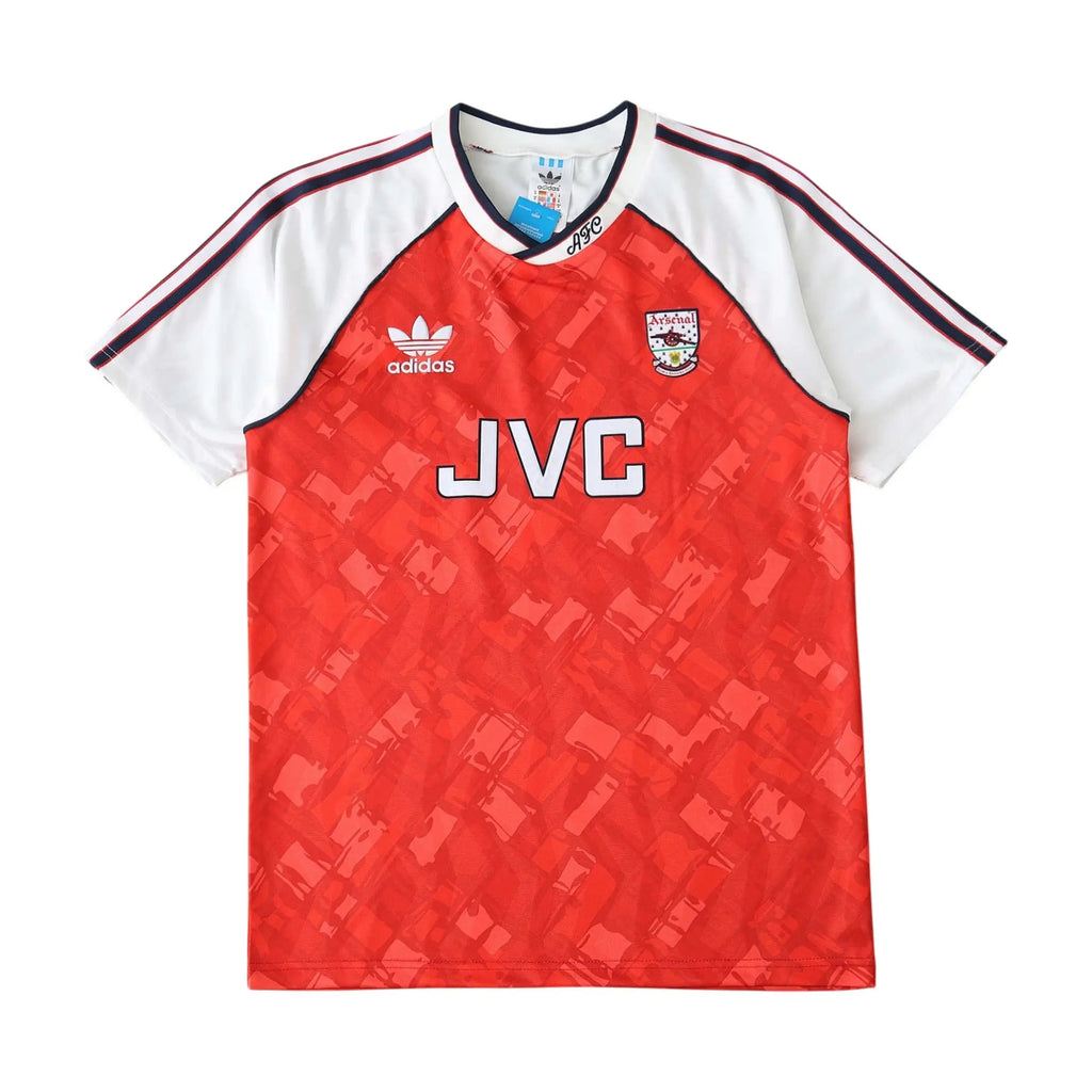 A vintage Adidas Arsenal home soccer jersey from the 1990-2000 era, featuring a red body with a subtle geometric pattern, white sleeves, and navy stripes on the shoulders. The front displays 'JVC' sponsor branding in white, the Adidas logo, and the Arsenal crest.