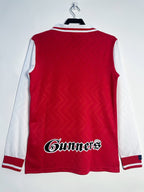 Red and white sports jersey with 'Gunners' logo on a white background