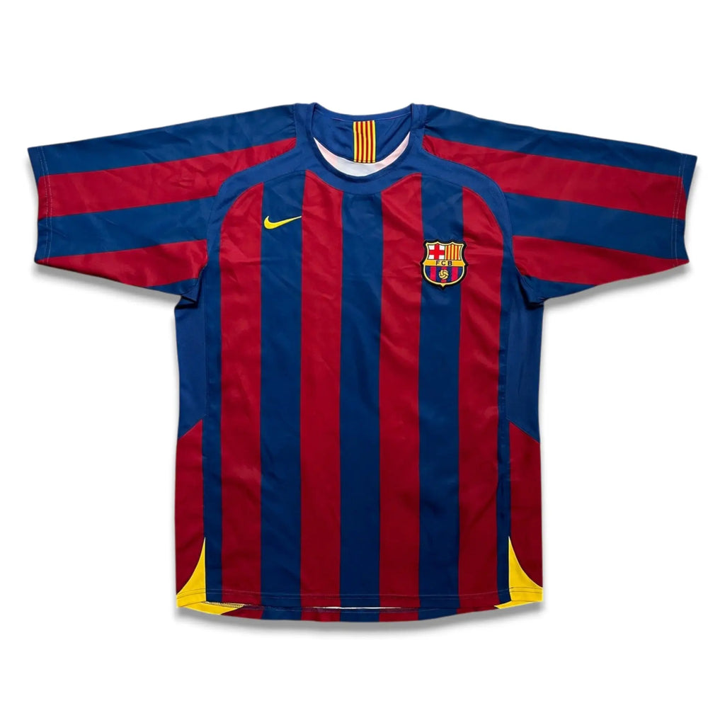 FC Barcelona home soccer jersey by Nike, featuring red and blue vertical stripes with yellow accents on the collar, swoosh, shoulders, and hem.