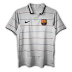 A gray short-sleeved soccer jersey with red and blue stripes, featuring the FC Barcelona crest and a Nike logo.