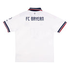 White FC Bayern Munich short-sleeve soccer jersey shown from the back, featuring 'FC BAYERN' printed in navy blue across the upper back, with navy and red striped trim on the collar and sleeve cuffs.