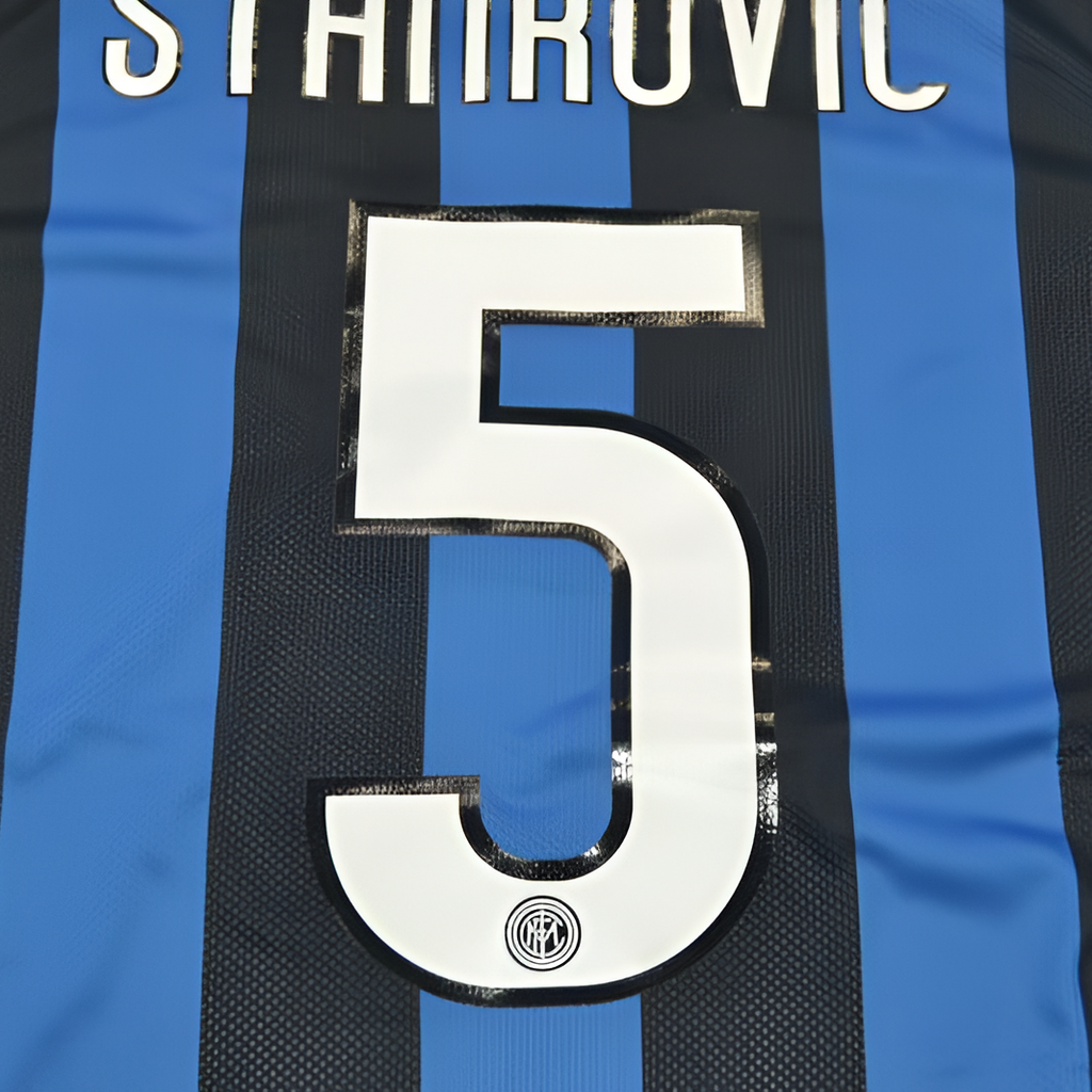 Close-up of the back of a black and blue striped soccer jersey with the name STANROVIC and the number 5 in white.
