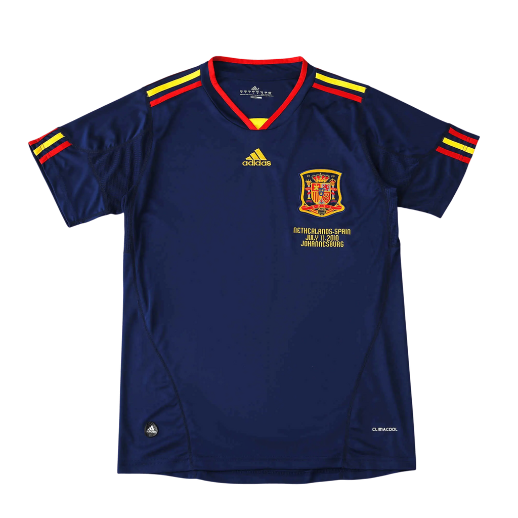 A navy blue Adidas Spain soccer jersey with red and yellow trim on the collar and sleeve cuffs, featuring the Spain national team crest and gold Adidas logo on the chest, displayed against a solid black background.