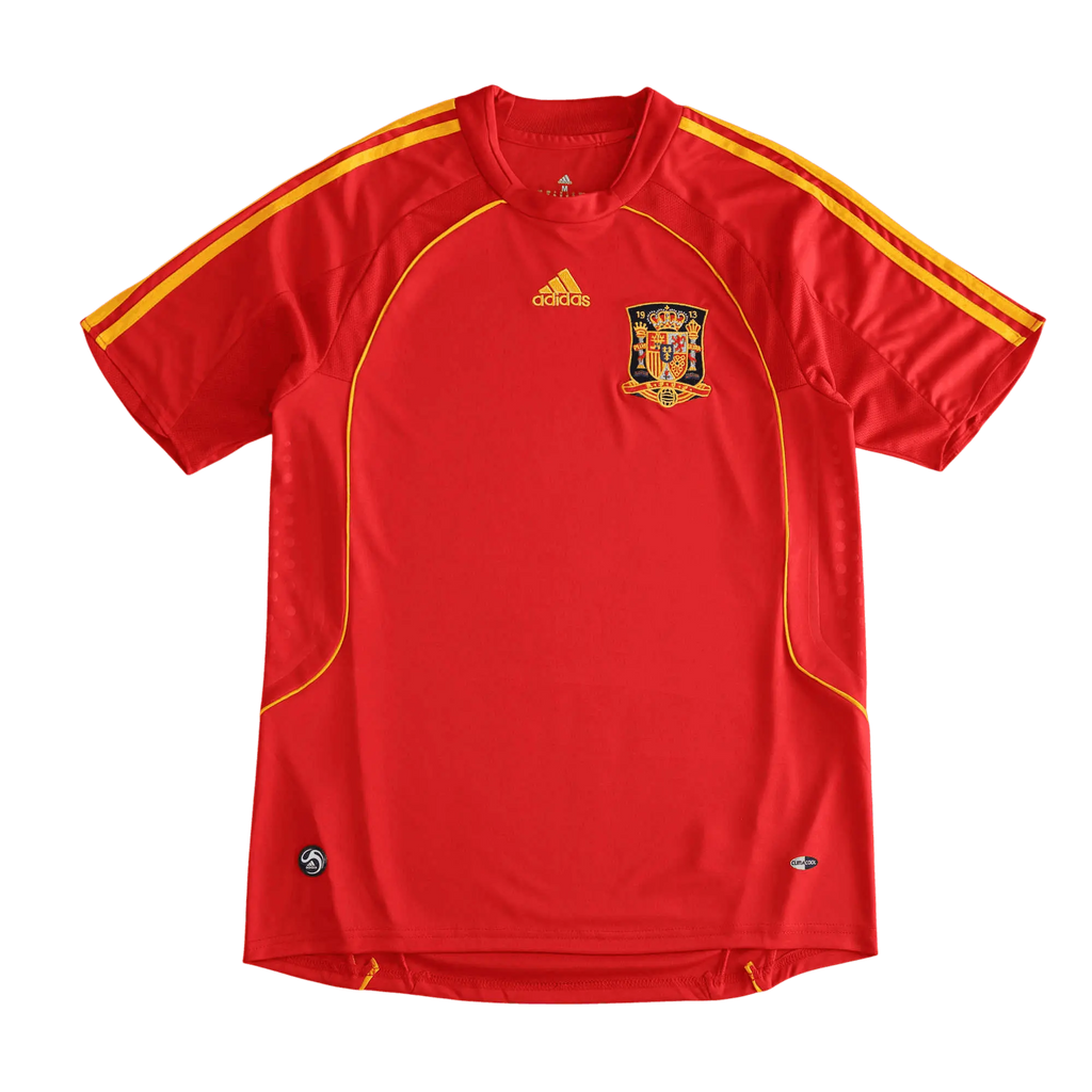 A red Spain national football team Adidas jersey with yellow stripes on the shoulders and sides, featuring the Spain crest on the chest, displayed against a solid black background.