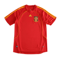 A red Spain national football team Adidas jersey with yellow stripes on the shoulders and sides, featuring the Spain crest on the chest, displayed against a solid black background.
