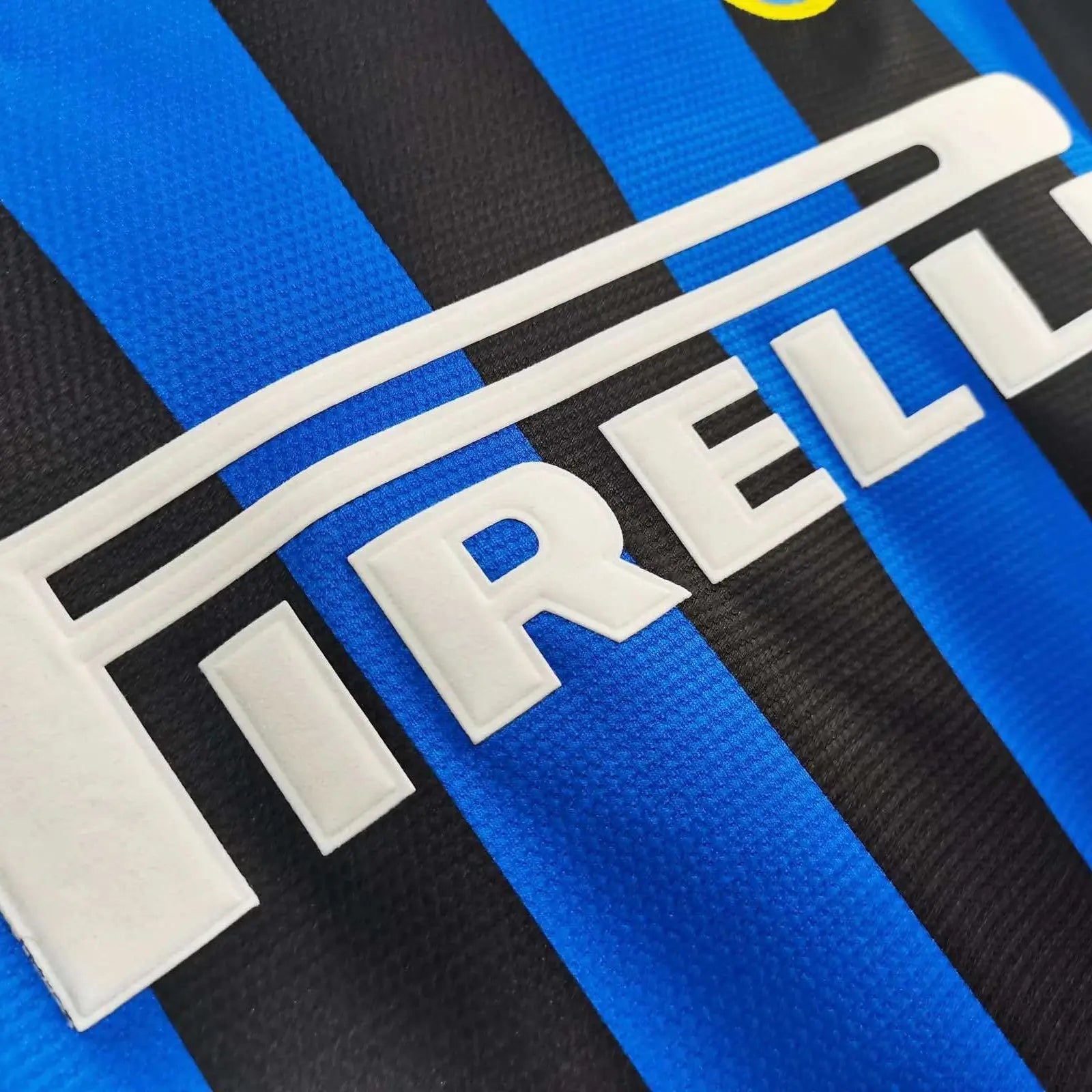 Close-up of a sports jersey with Pirelli logo on blue and black striped background