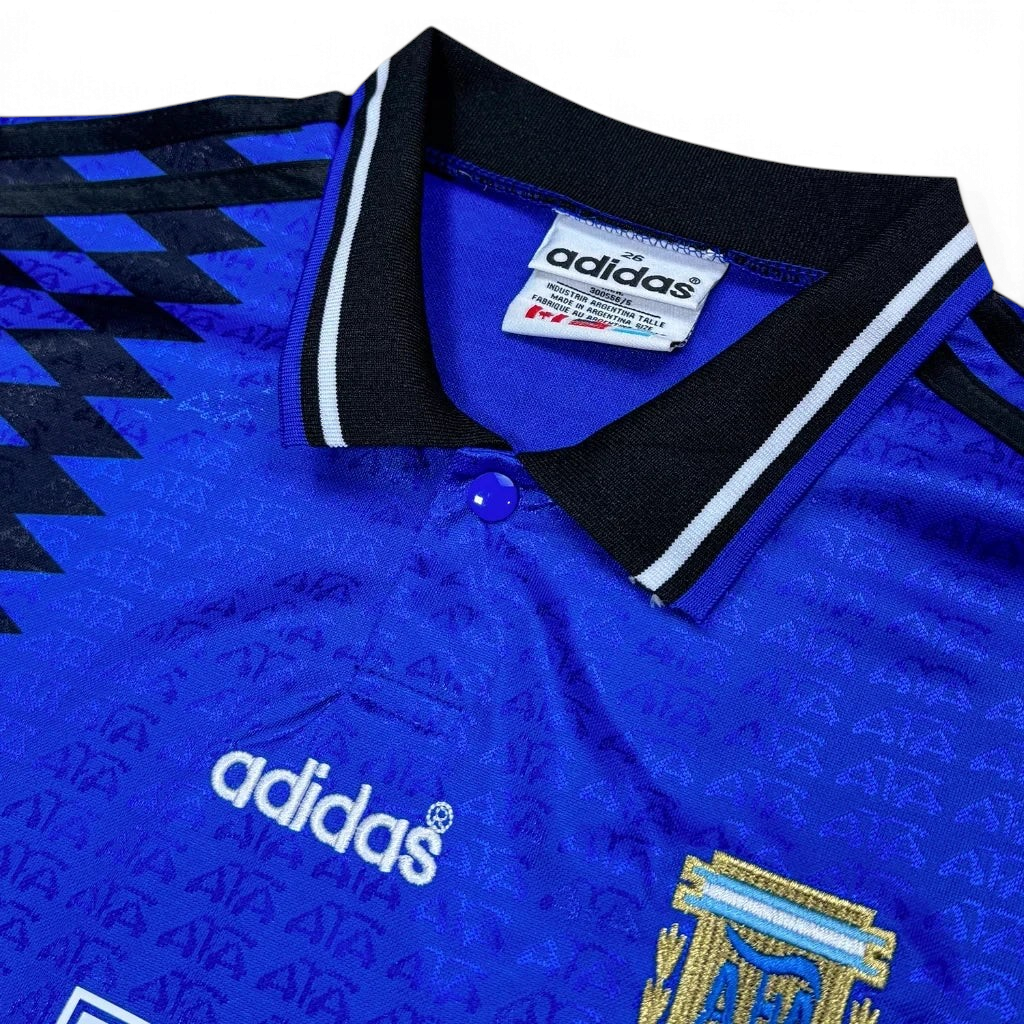 Elite Retro Kits Argentina 1994 away kids football shirt in blue with black diamond pattern, collar, and AFA crest.